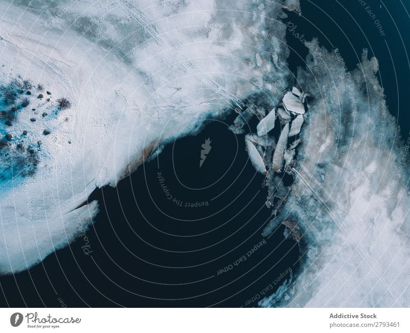 Eisplatten in der Nähe von schneebedeckten Ufern Platten Wasser Arktis Küste Schnee kalt kaputt Oberfläche Meer Frost Schaden Coolness dunkel Menschenleer