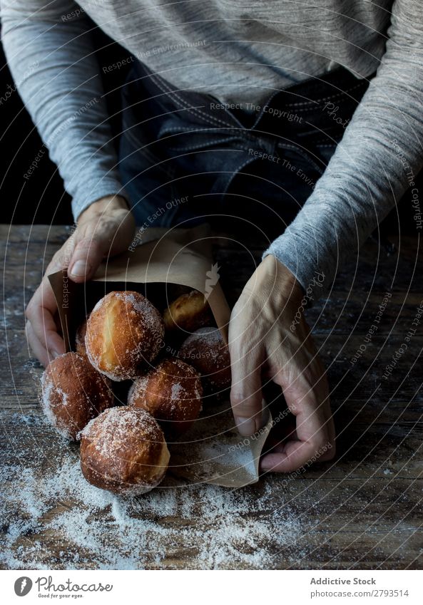 Person in der Nähe von gebackenen Kuchen auf dem Tisch Mensch Brotlaib Zucker gepulvert Lebensmittel Holz Backwaren Kulisse Mahlzeit Bäckerei süß Dessert