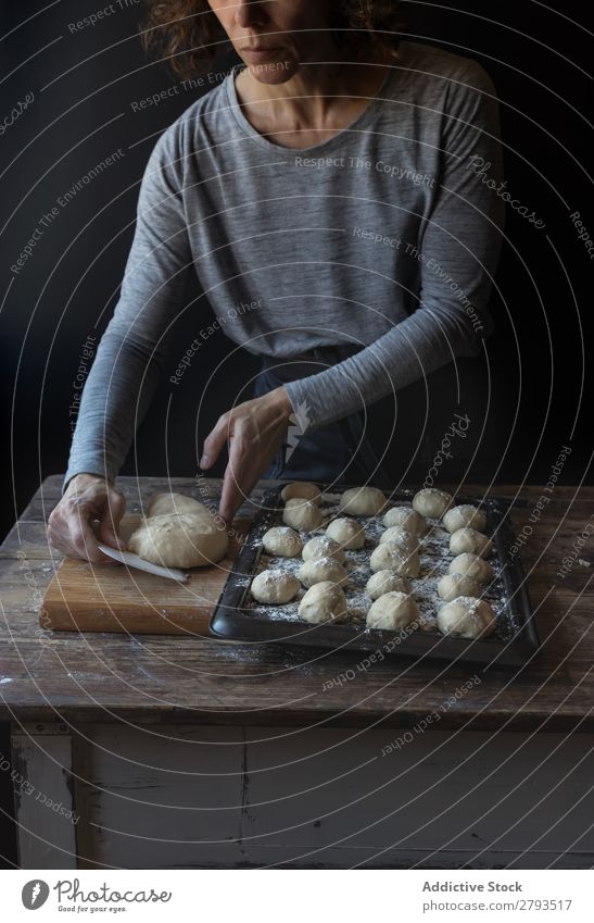 Person in der Nähe des Tabletts mit Teig und Mehl auf dem Tisch Kuchen Mensch Teigwaren Brotlaib Dunkelheit Lebensmittel Holz Backwaren Kulisse Mahlzeit