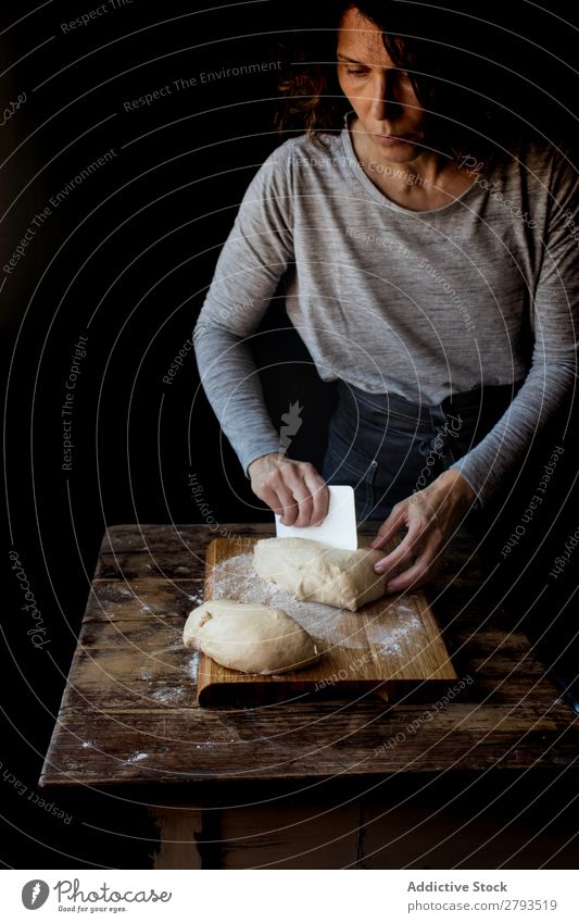 Person in der Nähe des Schneidebretts mit Teig und Mehl auf dem Tisch Mensch Teigwaren Brotlaib Holz Backwaren Kulisse Mahlzeit Bäckerei süß Dessert Pasteten