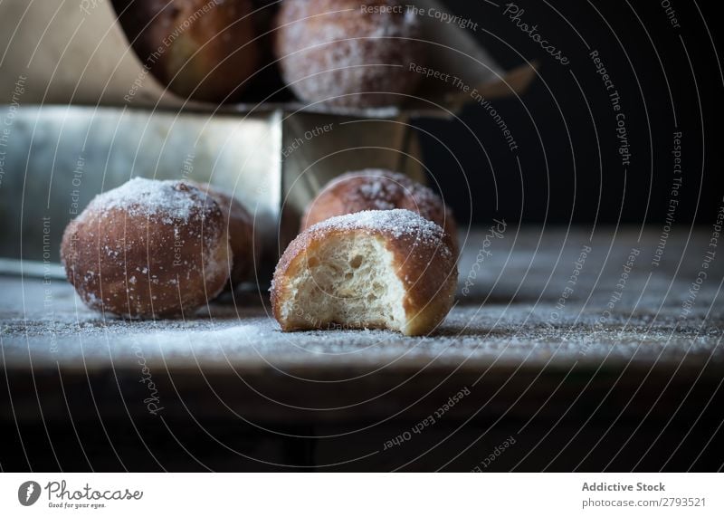 Gebackene Kuchen auf dem Tisch gebissen Kulisse Brotlaib Zucker gepulvert Dunkelheit Lebensmittel Backwaren Mahlzeit Bäckerei süß Dessert Pasteten Ernährung