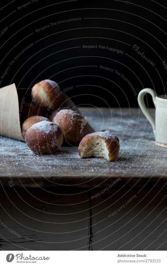 Gebackene Kuchen in Bastelpapier auf dem Tisch Handwerk Papier Brotlaib Zucker gepulvert Dunkelheit Lebensmittel Backwaren Kulisse Mahlzeit Bäckerei süß Dessert