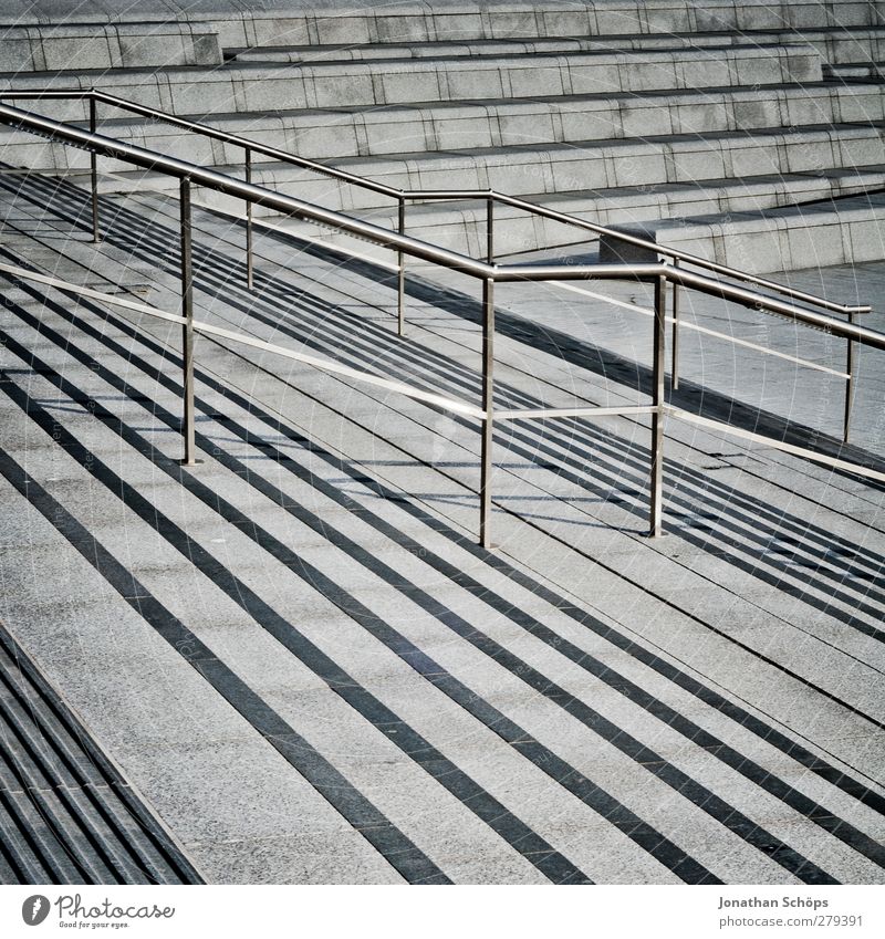 Treppengelände(r) Stadt Treppengeländer Geländer grau Beton trist Abstieg Neigung Mittagssonne Linie Geometrie Strukturen & Formen Strukturwandel Streifen