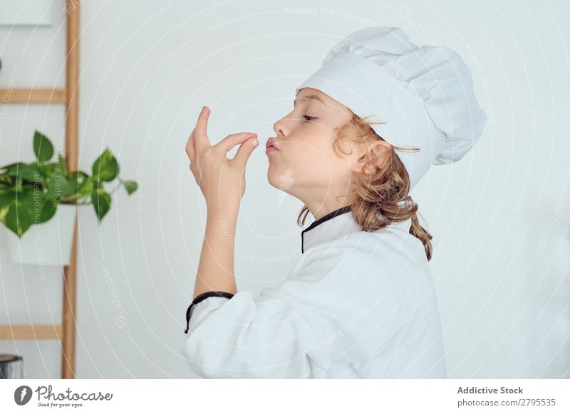 Junge mit Kochmütze mit leckerer Geste in der Küche Küchenchef Kind Hut Coolness gestikulieren kochen & garen modern heimwärts Feinschmecker zeigen Licht