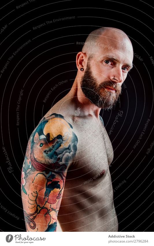 Junger bärtiger Kerl ohne Hemd mit Tattoos Mann Schickimicki Jugendliche Typ Glatze Hand zeigen gutaussehend Kunst Coolness Studioaufnahme Haut Design haarlos