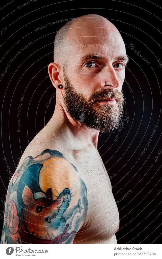 Junger bärtiger Kerl ohne Hemd mit Tattoos Mann Schickimicki Jugendliche Typ Glatze Hand zeigen gutaussehend Kunst Coolness Studioaufnahme Haut Design haarlos