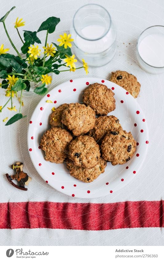 Kekse und Milch in der Nähe von Blumen Plätzchen Vase Tisch Teller Glas Flasche Haferflocken Frühstück Pferd Dekor Snack Dessert süß Lebensmittel gebastelt