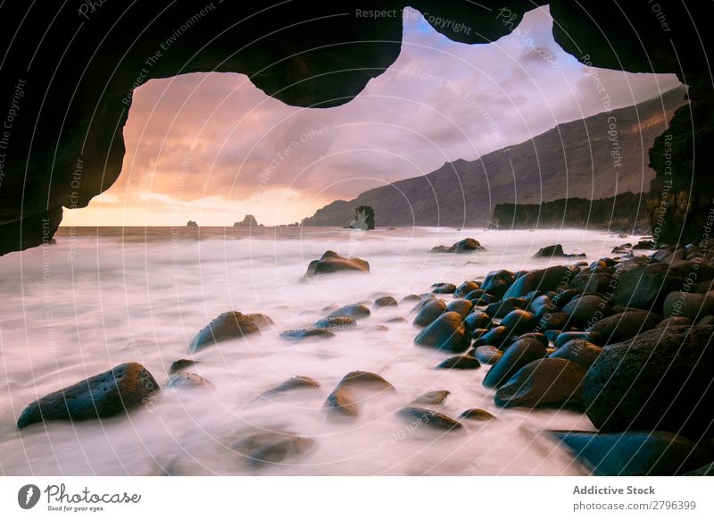 Erstaunliches Steinufer und rosa Himmel mit Wolken Küste Wasser hierro island Kanaren Spanien erstaunlich Meer Oberfläche Sonnenuntergang Felsen malerisch