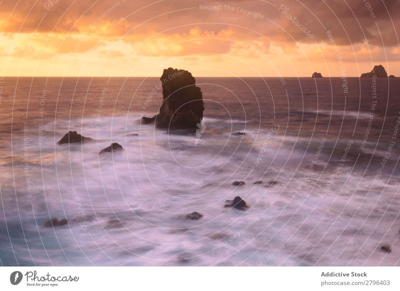 Erstaunliches Steinufer und rosa Himmel mit Wolken Küste Wasser hierro island Kanaren Spanien erstaunlich Meer Oberfläche Sonnenuntergang Felsen malerisch