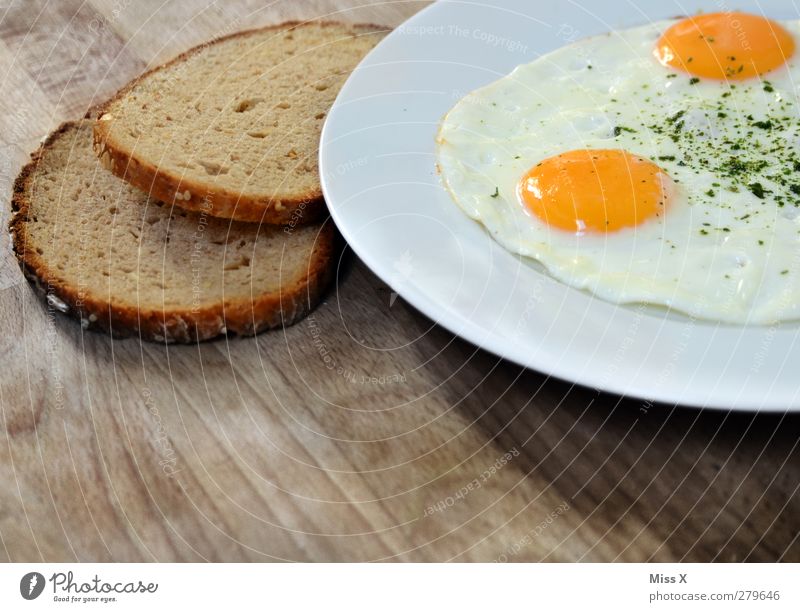 Frühstück Lebensmittel Brot Ernährung Mittagessen Abendessen Teller lecker gelb weiß Spiegelei Hühnerei Brotscheibe Holztisch rustikal Farbfoto Nahaufnahme