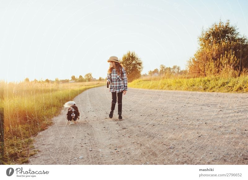 fröhliches Kind Mädchen geht mit ihrem Hund auf der Landstraße spazieren. Lifestyle Freude Freizeit & Hobby Spielen Ferien & Urlaub & Reisen Ausflug Abenteuer