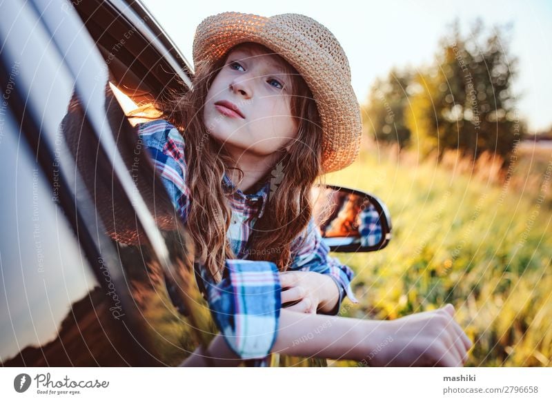 fröhliches Kind Mädchen, das aus dem Autofenster schaut. Lifestyle Freude Freizeit & Hobby Spielen Ferien & Urlaub & Reisen Ausflug Abenteuer Freiheit