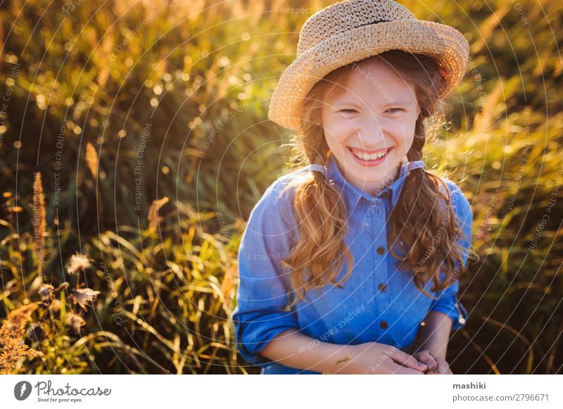 fröhliches Mädchen in blauem Kleid und Stroh, das im Sommer spazieren geht Lifestyle Freude Glück Leben Erholung Freizeit & Hobby Spielen