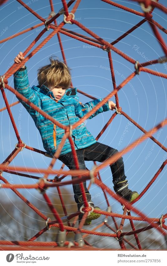 Kind Klettert auf dem Spielplatz Mensch Junge Kindheit 1 3-8 Jahre Umwelt Natur Himmel Wolkenloser Himmel Winter Bewegung festhalten Spielen authentisch