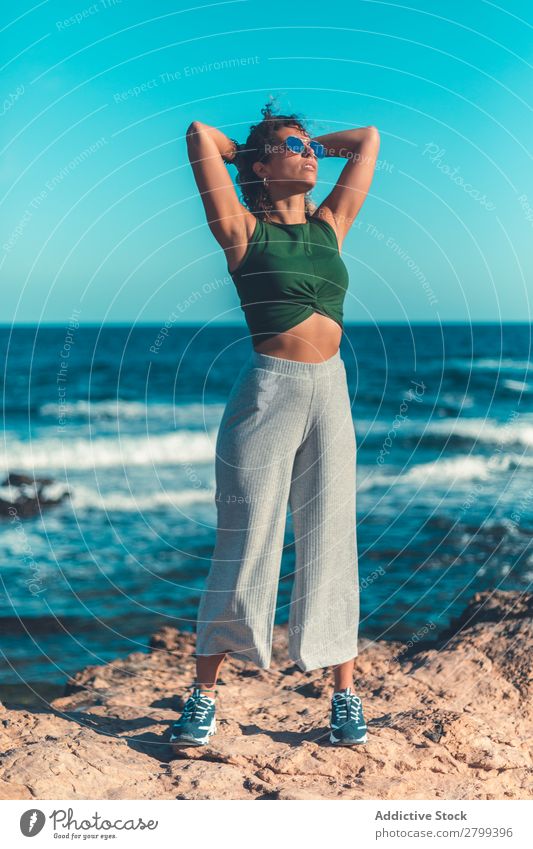 Stilvolle Frau am Meer stehend Küste träumen Lifestyle Freizeit & Hobby ruhen Erholung Wellen Wasser trendy lässig Sonnenbrille Himmel blau Schönes Wetter Dame