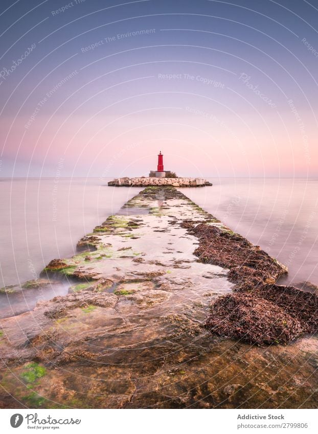 Rauher Weg zur Insel mit Leuchtturm Wege & Pfade Meer Inselchen rau Stein Sonnenaufgang Morgen Himmel Ferien & Urlaub & Reisen Wasser Schaden Leuchtfeuer