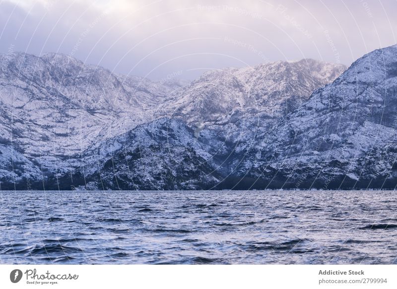 Ufer mit Bergen am Wasser Küste Berge u. Gebirge Felsen Klippe Stein Himmel Wolken Oberfläche winkend erstaunlich weiß natürlich Aussicht Hügel Landen