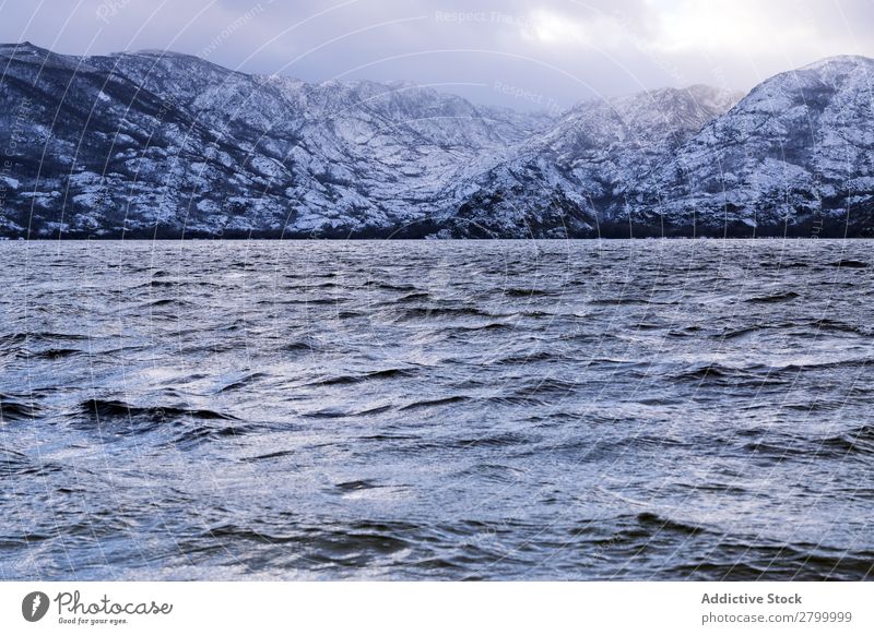 Ufer mit Bergen am Wasser Küste Schnee Berge u. Gebirge Felsen Klippe Stein Himmel Wolken Oberfläche winkend erstaunlich weiß natürlich Aussicht Hügel Landen