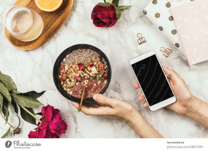 Hände halten Smoothie Schale mit Laptop, Pfingstrosen und Wasser Frühstück Chiapudding Diät Getränk trinken Frau flach Flachlegung Blume Lebensmittel