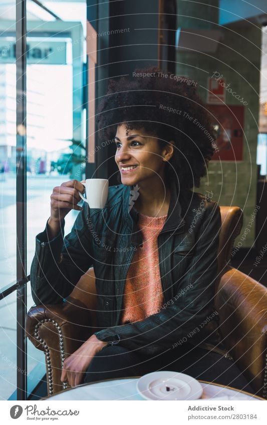 Schwarze Frau mit Afrohaar, die einen Kaffee trinkt. Afrikanisch Afro-Look Amerikaner attraktiv schön Beautyfotografie schwarz lässig Tasse trinken Mode Mädchen