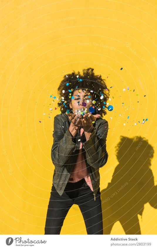 Schwarze Frau mit Afrohaar, die mit Konfetti feiert. Afrikanisch Afro-Look Hintergrundbild schön Beautyfotografie Geburtstag blau Gast Feste & Feiern mehrfarbig