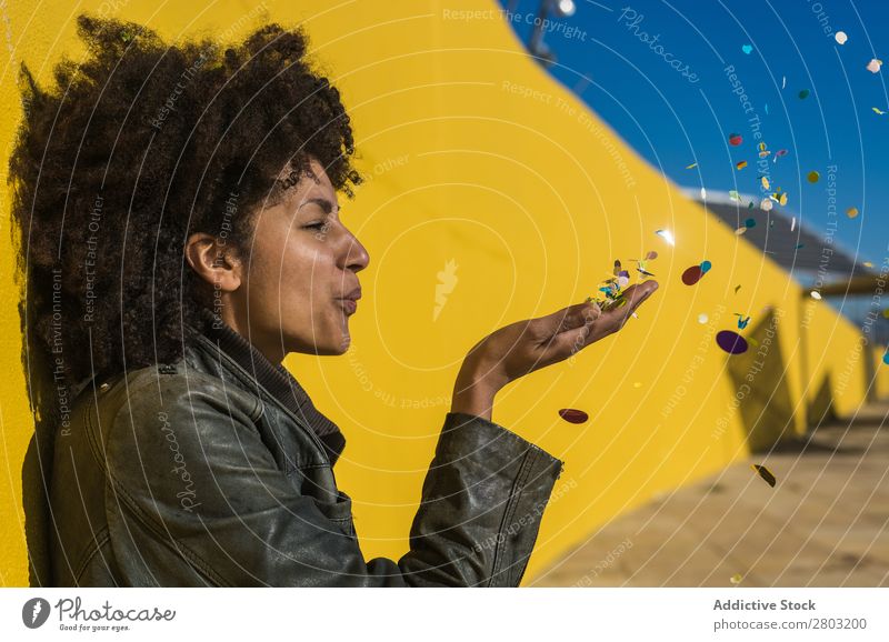 Schwarze Frau mit Afrohaar, die mit Konfetti feiert. Afrikanisch Afro-Look Hintergrundbild schön Beautyfotografie Geburtstag blau Gast Feste & Feiern mehrfarbig