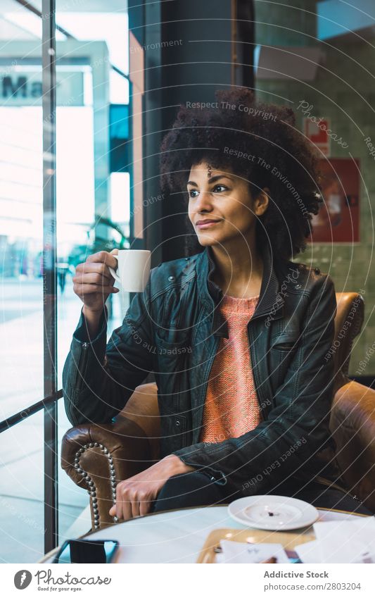 Schwarze Frau mit Afrohaar, die einen Kaffee trinkt. Afrikanisch Afro-Look Amerikaner attraktiv schön Beautyfotografie schwarz lässig Tasse trinken Mode Mädchen