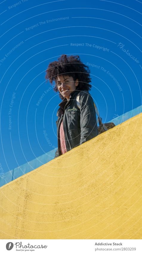 Schwarze Frau mit Afrohaar, die sich an bunte Wände lehnt. Erwachsene Afrikanisch Afro-Look Amerikaner Hintergrundbild schön Beautyfotografie schwarz blau