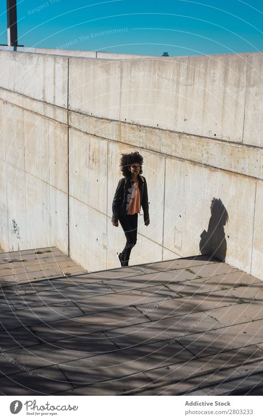 Eine schwarze Frau geht die Straße entlang. Afrikanisch Amerikaner attraktiv Tasche schön Körper lässig Solarzelle Handy Großstadt Mode voll Glück Halt