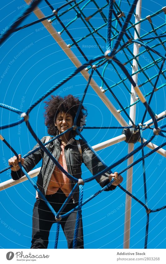 Frau mit Afrohaar klettert bei Kinderattraktionen. Aktion Afrikanisch Afro-Look schwarz heiter Kindheit Klettern niedlich Gerät Familie & Verwandtschaft Freude