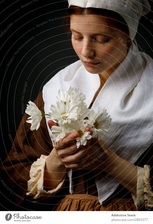 Mittelalterliches Dienstmädchen mit Blumen mittelalterlich rothaarig Frau Halt Margeriten Bekleidung historisch Kleid Kostüm Jungfer Motorhaube Renaissance