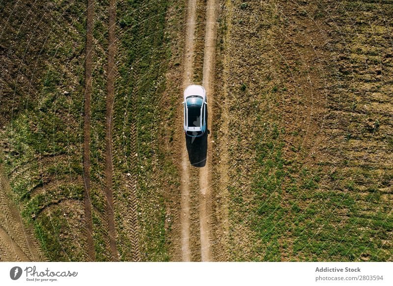 Luftaufnahme eines Autos über einen unbefestigten Weg Aussicht Fluggerät Straße PKW Landschaft Fahrzeug Top Erde Dröhnen schwarz fahren pov Länder Natur Feld