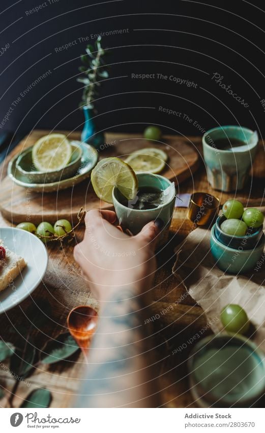 Anordnung des Keramikgeschirrs auf Holztisch Tisch Weintrauben Utensil Design rustikal frisch Zitrone Kunstgewerbler Frucht Platten Kreativität natürlich