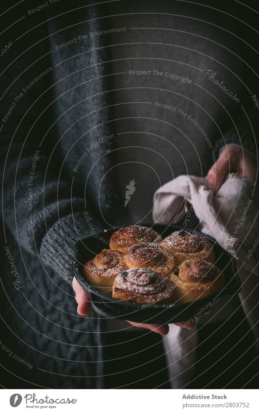 Getreidefrau mit Zimtrolle Frau Saucen Halt Serviette Zimtbrötchen Brötchen Pfanne Lebensmittel Mahlzeit frisch rustikal Feinschmecker Tradition Speise