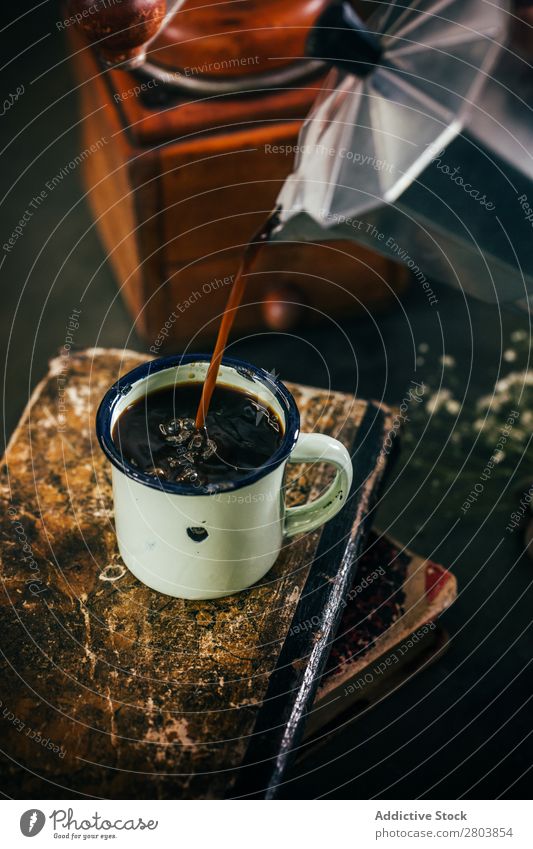 Portionieren von heißem Kaffee in einer Email-Tasse Antiquität aromatisch Bohnen Getränk schwarz Buch Frühstück Koffein Kaffeepause Kaffeekanne Creme trinken