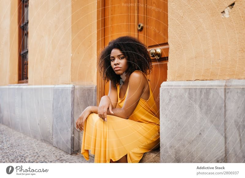 Wunderschöne schwarze Frau in Kleid auf der Straße. Tür lockig Stadt genießen Barfuß traumhaft urwüchsig Afroamerikaner Afro-Look Angebot Körper selbstbewußt