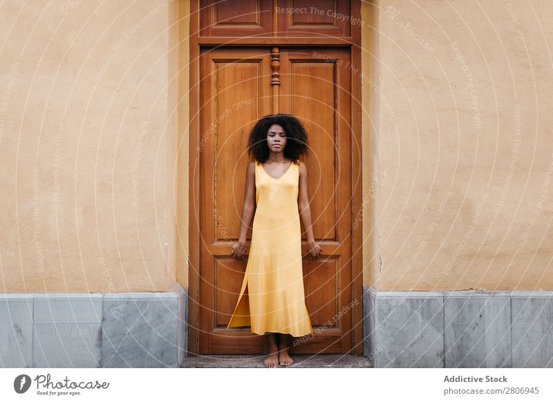 Wunderschöne schwarze Frau in Kleid auf der Straße. Tür lockig Stadt genießen Barfuß traumhaft urwüchsig Afroamerikaner Afro-Look Angebot Körper selbstbewußt