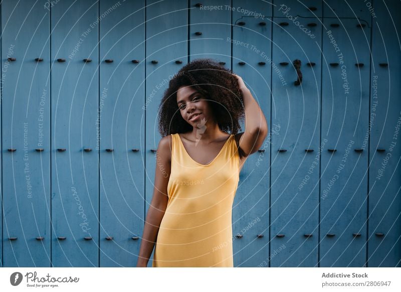 Wunderschöne schwarze Frau in Kleid auf der Straße. Tür blau lockig Stadt genießen Barfuß traumhaft urwüchsig Afroamerikaner Afro-Look Angebot Körper