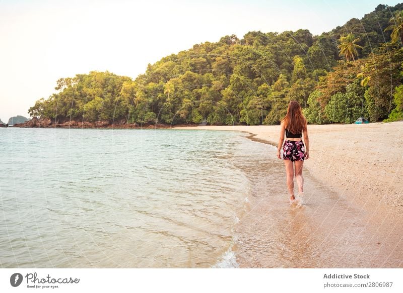 Frau, die am Sandufer in der Nähe des Wassers spazieren geht. Strand Meer laufen Jamaika Wald Küste tropisch exotisch Sommer Spielen dünn Dame Handfläche