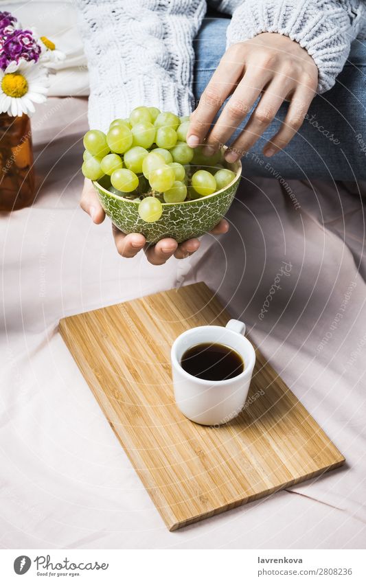 Frauenhände im Pullover mit Holzschale und Trauben Herbst Ernte gemütlich natürlich Sommer frisch Nahaufnahme Frucht organisch reif Essen Bett Bettwäsche Decke