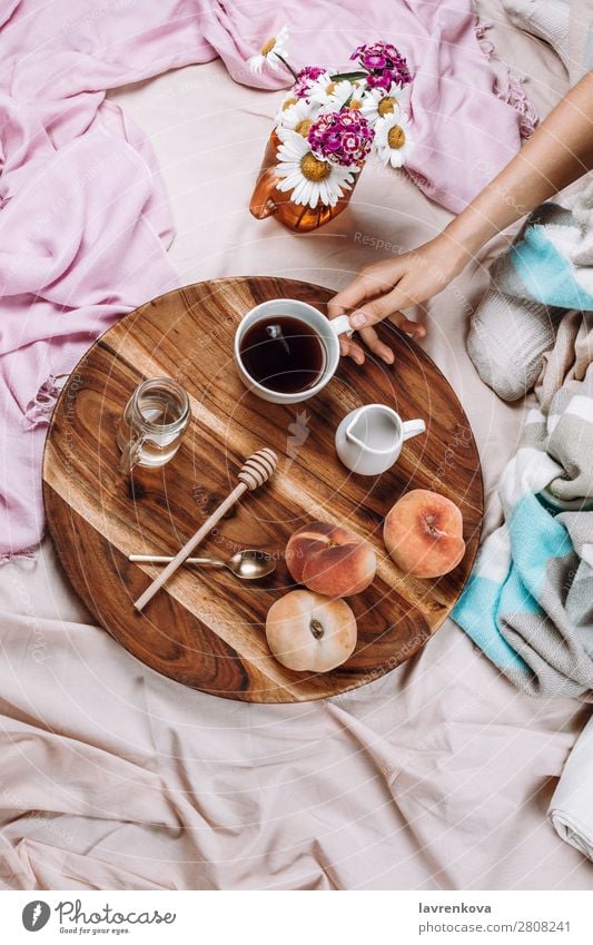 Gemütliches Flachbett aus Holztablett mit Tasse Kaffee, Pfirsichen, Kaffeesahne und Sahne. Becher Flachlegung flache Verlegung Schlafzimmer Frühstück Espresso