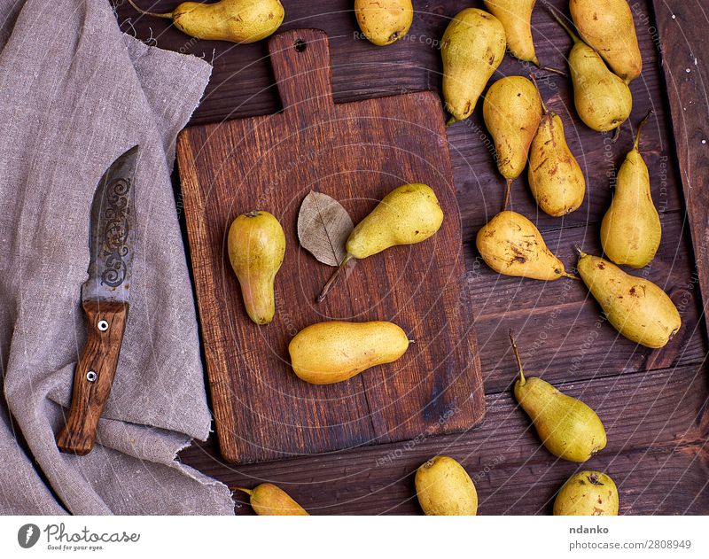 Birnen verstreut auf einem braunen Holztisch Frucht Ernährung Vegetarische Ernährung Diät Tisch alt Essen frisch lecker natürlich oben gelb grün Holzplatte