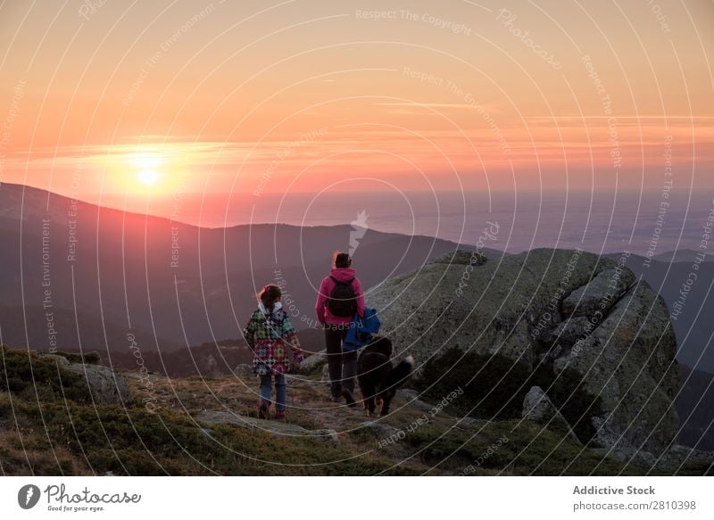 Mutter und Tochter beobachten den Sonnenuntergang auf dem Gipfel des Berges. wandern Ferien & Urlaub & Reisen Kind Frau Ausflug Berge u. Gebirge Sonnenaufgang