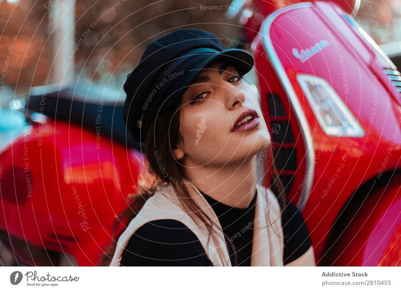 Junge hübsche Frau am Roller Stil Jugendliche Straße Kleinmotorrad rot Motorrad Mütze schön Großstadt Mode attraktiv Model Mensch Beautyfotografie Porträt Stadt