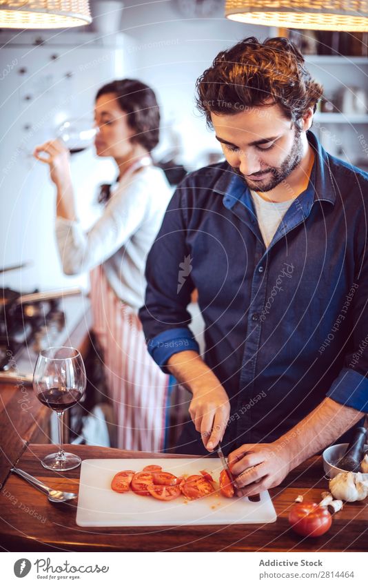 Junges Paar beim Kochen. Mann und Frau in der Küche kochen & garen heimwärts Abendessen Jugendliche Essen Ehefrau Erwachsene Lächeln Innenarchitektur Ehemann