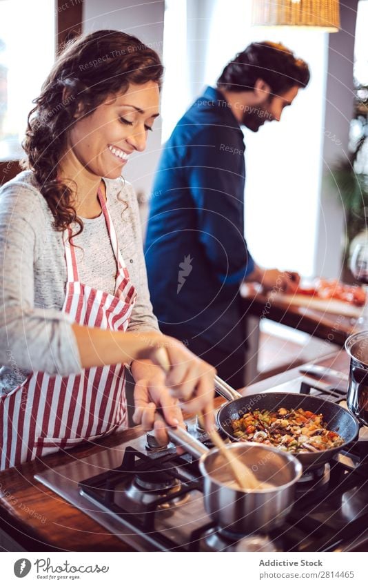 Junges Paar beim Kochen. Mann und Frau in der Küche kochen & garen heimwärts Abendessen Jugendliche Essen Ehefrau Erwachsene Lächeln Innenarchitektur Ehemann