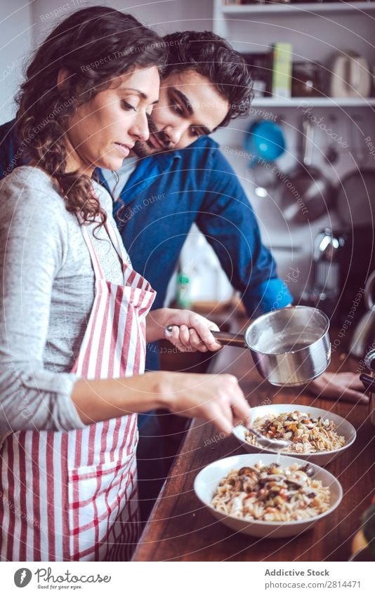 Junges Paar beim Kochen. Mann und Frau in der Küche kochen & garen heimwärts Abendessen Jugendliche Essen Ehefrau Erwachsene Lächeln Innenarchitektur Ehemann