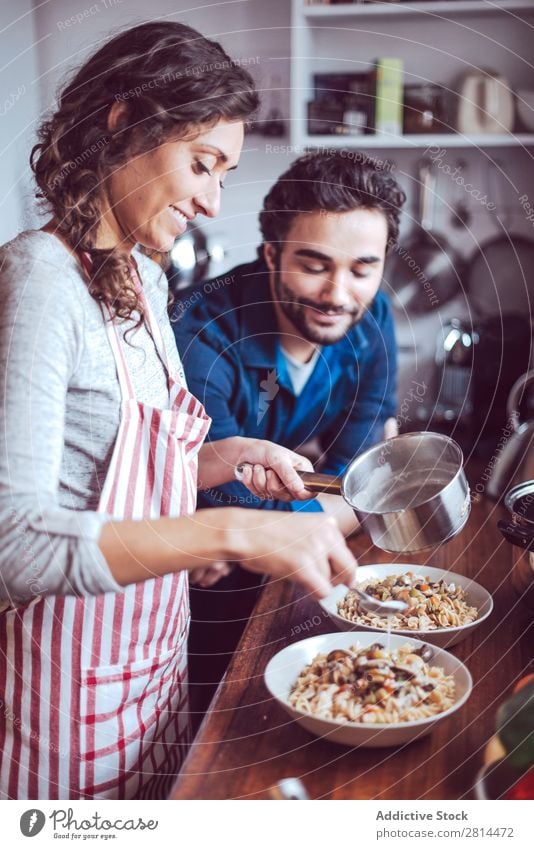 Junges Paar beim Kochen. Mann und Frau in der Küche kochen & garen heimwärts Abendessen Jugendliche Essen Ehefrau Erwachsene Lächeln Innenarchitektur Ehemann