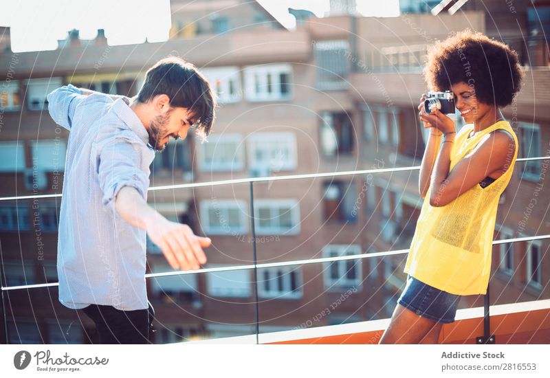 Interrassisches junges Paar, das sich gegenseitig fotografiert und Spaß hat. Jugendliche gutaussehend multikulturell interrassisch Sommer Außenaufnahme lässig