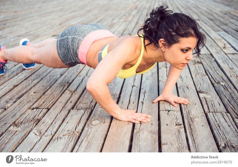 Junge Frau, die im Freien arbeitet und Spaß hat. Außenaufnahme sportlich Fitness Sporthalle Sommer Training Park Liegestütze dünn Tatkraft Erwachsene stark